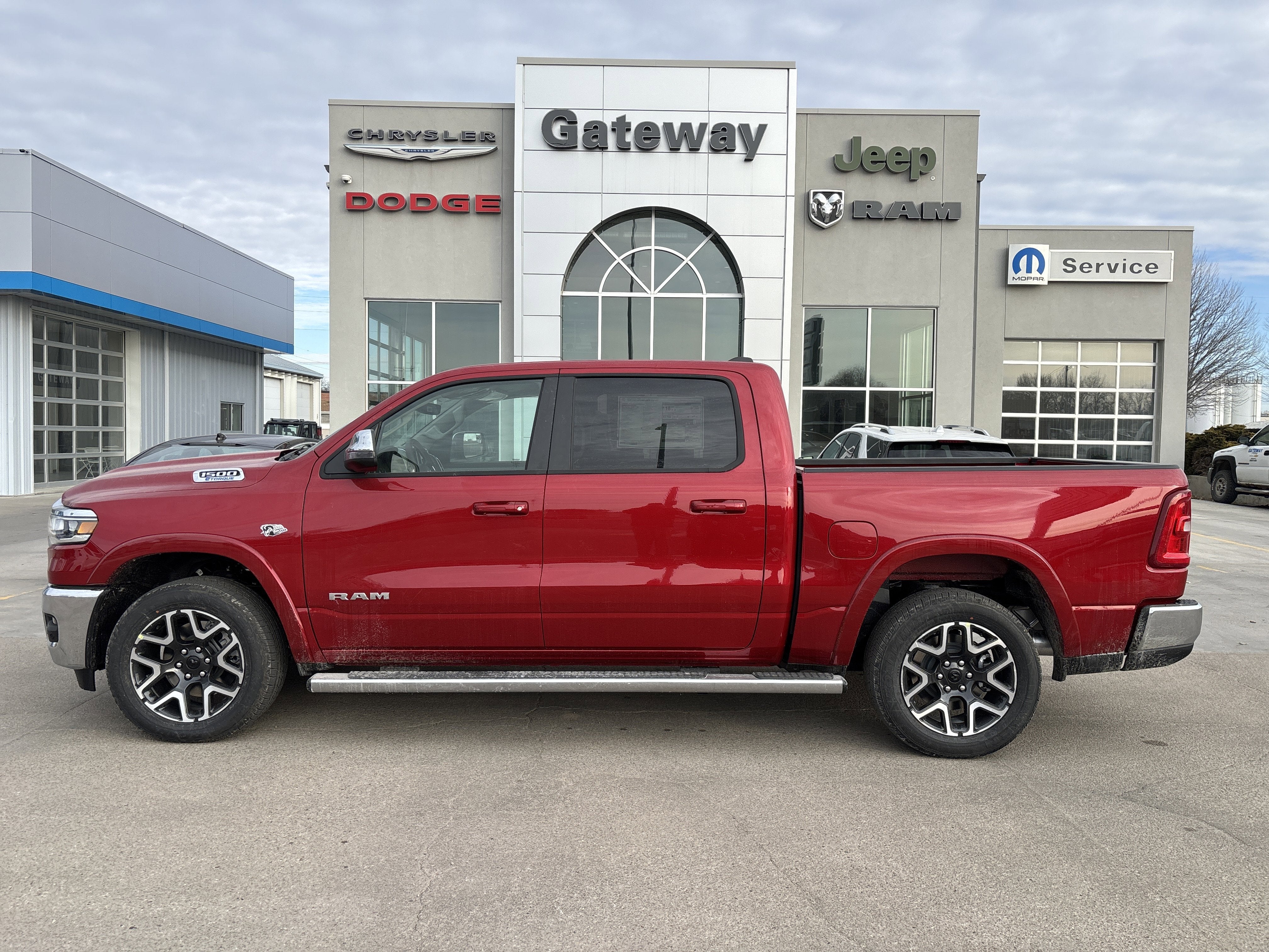 2026 RAM Ram 1500 RAM 1500 LARAMIE CREW CAB 4X4 5'7' BOX in Molten Red Pearl-Coat Exterior Paint — front three-quarter view